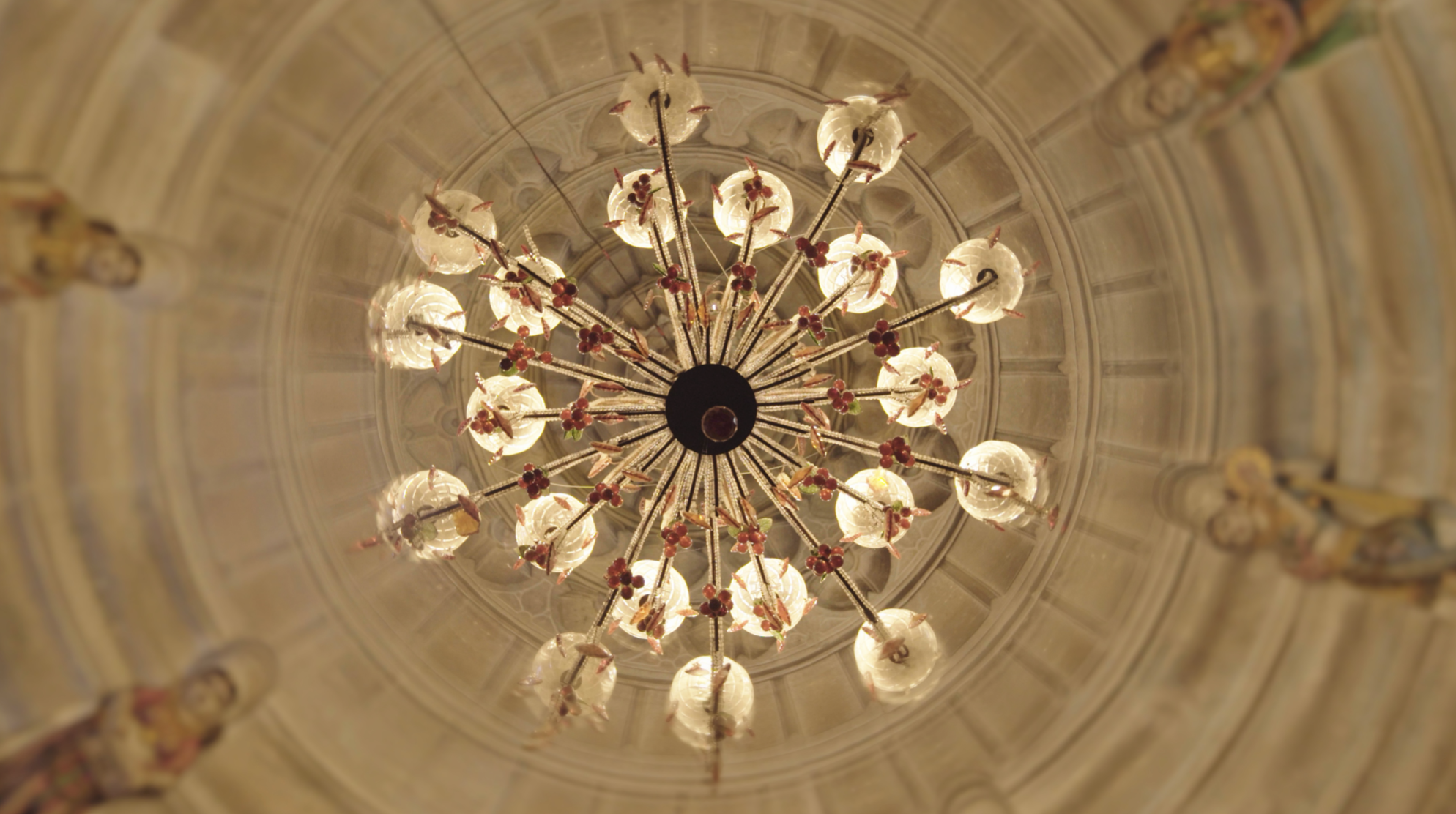 Chandelier viewed from below in ornate domed ceiling